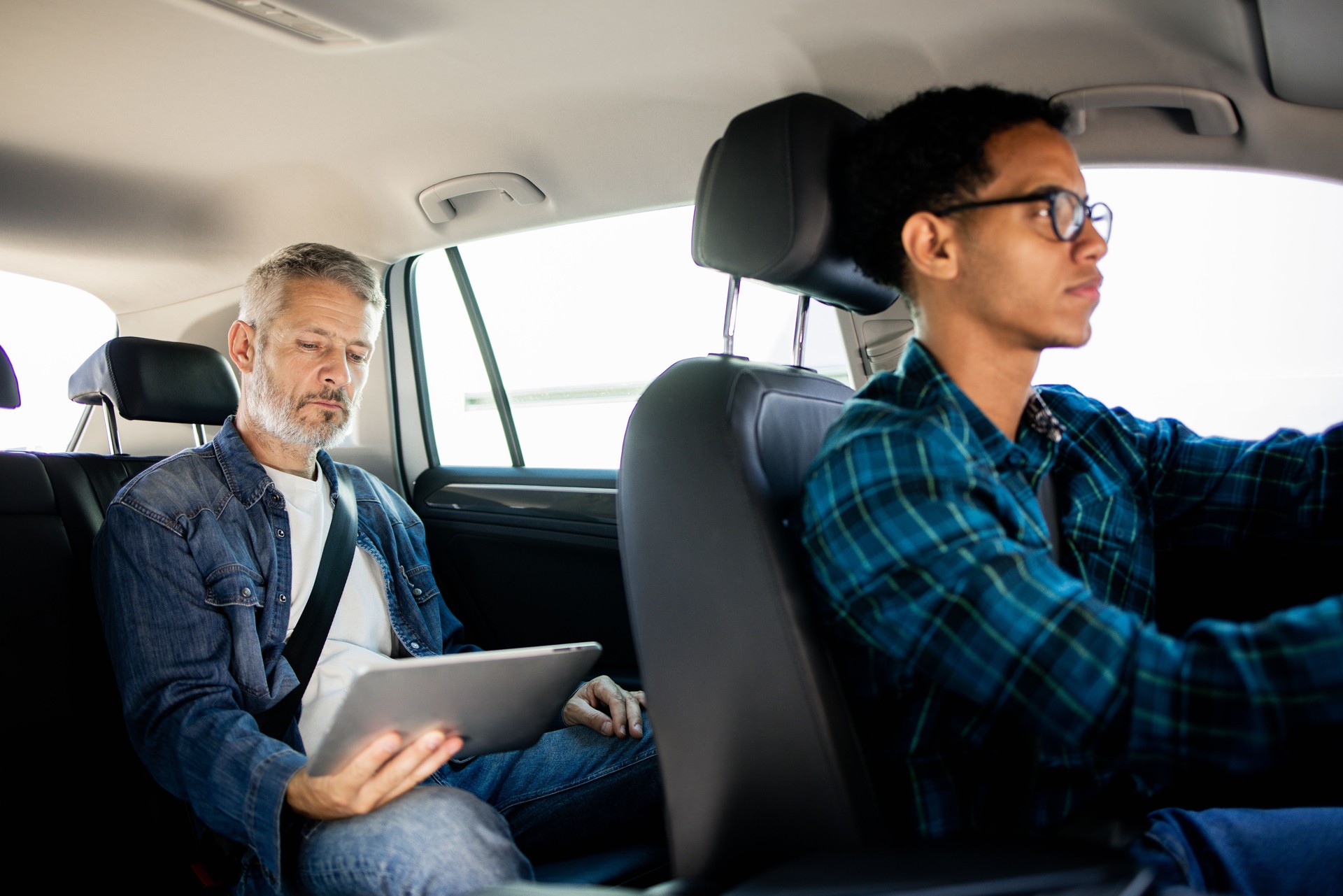 Young taxi driver driving a businessman